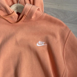 Nike hoodie - nike hoodie i en somrig korall färg (orangerosa), mycket fint skick och inga defekter då den knappt är använd 😌skriv för frågor eller fler bilder 