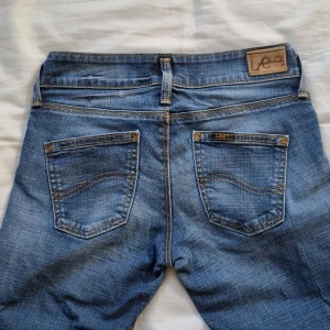Lågmidjade jeans Lee - Lågmidjade jeans från Lee. Rak modell med lite utsvängning. W26 L31. Bra skick. Köparen står för frakt. 