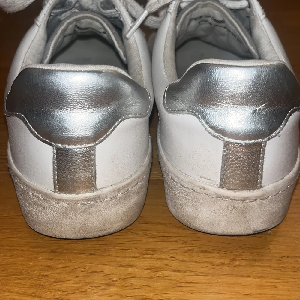 Ett par grå vita sneakers med stjärna på.⭐️Köptes för 660kr på Zalando. Storlek 41 men sitter mer som 40.😊. Skor.