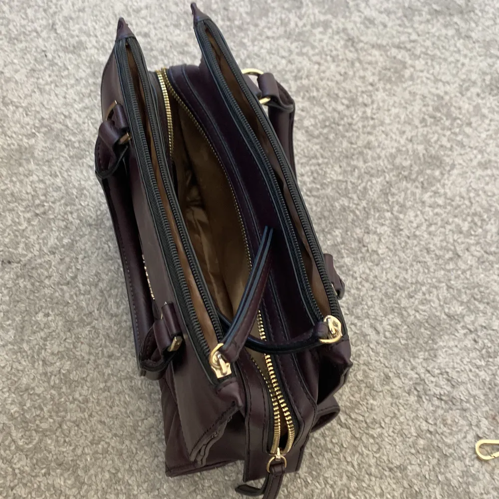 En jättefin handväska från fiorelli i en vinröd färg med gulddetaljer💛 Man kan ha den med eller utan axelrem och den har många olika fack vilket gör den väldigt rymlig. Frakt 60 kr. Väskor.
