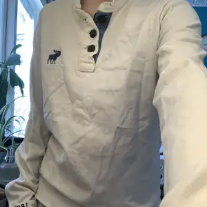 Snygg vit abercrombie & fitch tröja med blå detaljer och bruna knappar :)