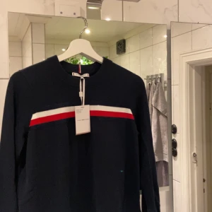 Tommy Hilfiger Sweater - En helt oanvänd tröja från Tommy Hilfiger Storlek M Nypris 1450 Säljes pga att jag fick en tjejtröja fast ville ha killtröja!