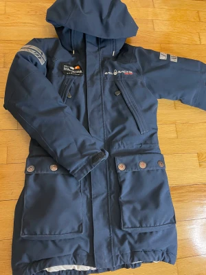 Sail racing  vinterjacka. - Märke: sail racing  Färg: mörk blå.  Strl: xs (något liten i strl, passar perfekt för mig som är petite)  Justerbar i midjan. Knappar vid sidorna.   Absolut den varmaste jackan jag har haft.  Har älskat den varje vinter. Perfekt för en som fryser som jag.