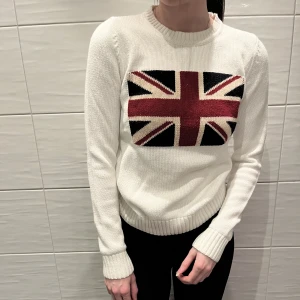 Finstickad tröja - Finstickad tröja med en flagga på. Väldigt skön och i fint skick. Storleken är xs och passar nog en xxs också. Frakt är inte inkluderat i priset och betalning sker via Swish🤍🤍