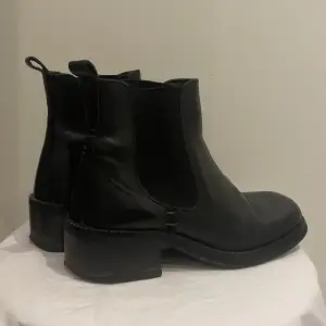 Ett par snygga svarta läder boots som säljs på grund av för liten storlek. De är i storlek 38
