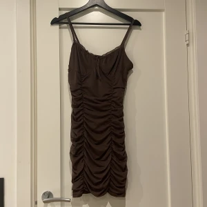 Sommarklänning från H&M - Superfin mörkbrun klänning som sitter som en smek på kroppen och verkligen framhäver ens kurvor. Har används ca 5 gånger så är i bra skick. Den är i stl S och slutar en bit över knäna. 