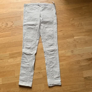 Beiga byxor! - Fina, smala bomullsbyxor i ljusbeige. Låg midja. Detalj fram med fickorna samt ’lappar’ på benen. Sidoblixtlås. Inga fickor bak. Inköpta i designerbutiken Best of Brands men etikett saknas då jag ej tål dem. Använda 2-3 gånger men passar mig inte längre