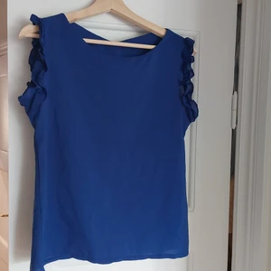 Blus - okänt märke. Stlr. M  - En blus med puffiga ärmar som använts väldigt sparsamt. Passar perfekt till ett par jeans eller kjol.