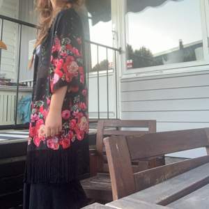 Blommig ”kimono” med fransar nedtill. Jag är 170 och den sitter löst och flowy på mig.
