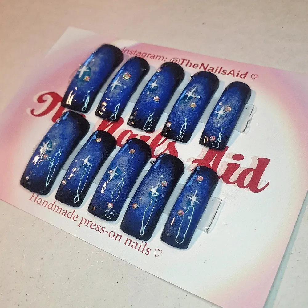Handmålade snygga blå/svarta y2k presson naglar (naglar man limmar på), space themed o super fina!   • Kolla in @TheNailsAid på instagram för fler designs och detaljer ! följ gärna 💗🌸 . Övrigt.