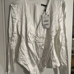 Vit zara body - Vit satäng body från zara. Gillade inte passformen så de kom aldrig till användning. Prislappen finns kvar.