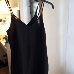 KLÄNNING NAKD - Fin svart klänning i satin från NAKD. Aldrig använd med lapp kvar. E genomskinlig på. Lappen var missfärgad när jag fick hem den men inget som syns på plagget. Går ungefär till mitten på låren. Passar även S :) eventuell frakt betalas av köparen! 