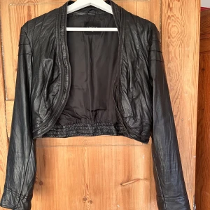 Bolero i skinn - Bolero i mycket naturtroget skinnmateriel med dragkedjedetaljer!