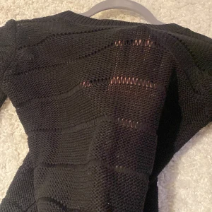 Randig svart stickad  - Genomskinliga ränder. Så fin med en svart spets bh eller linne under. Nyskick 