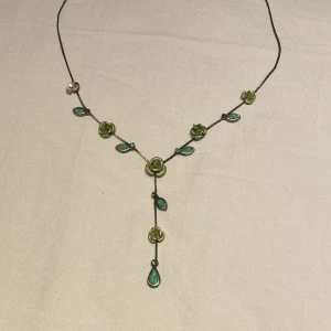 Halsband  - Ett jättefint halsband med gröna blommor på, en av blommorna är lite trasig men det är inget man tänker på.💕