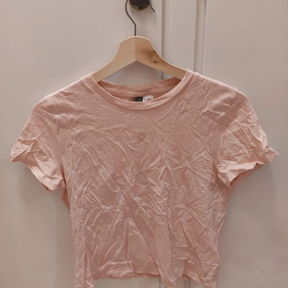 En rosa t-shirt med ett broderat rosa hjärta. Använt ett fåtal gånger och är i bra skick. Den är i st S från H&M. 25kr+frakt. T-shirts.