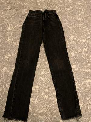Ett par svarta jeans med slitningar och slits längst ner från Gina tricot! Använda, men kan inte se några defekter. Storlek 32.