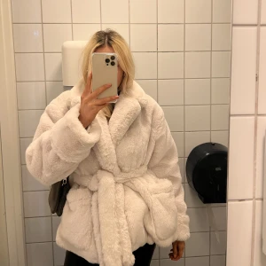 Pälsjacka - Vit fluffig jacka från Bubbleroom, använd ett fåtal gånger. Släpper lite av håret så därför nedsatt pris. (Intressekoll), (andra bilden har ett filter som gör att jackan ser mörkare ut, men den är vit)