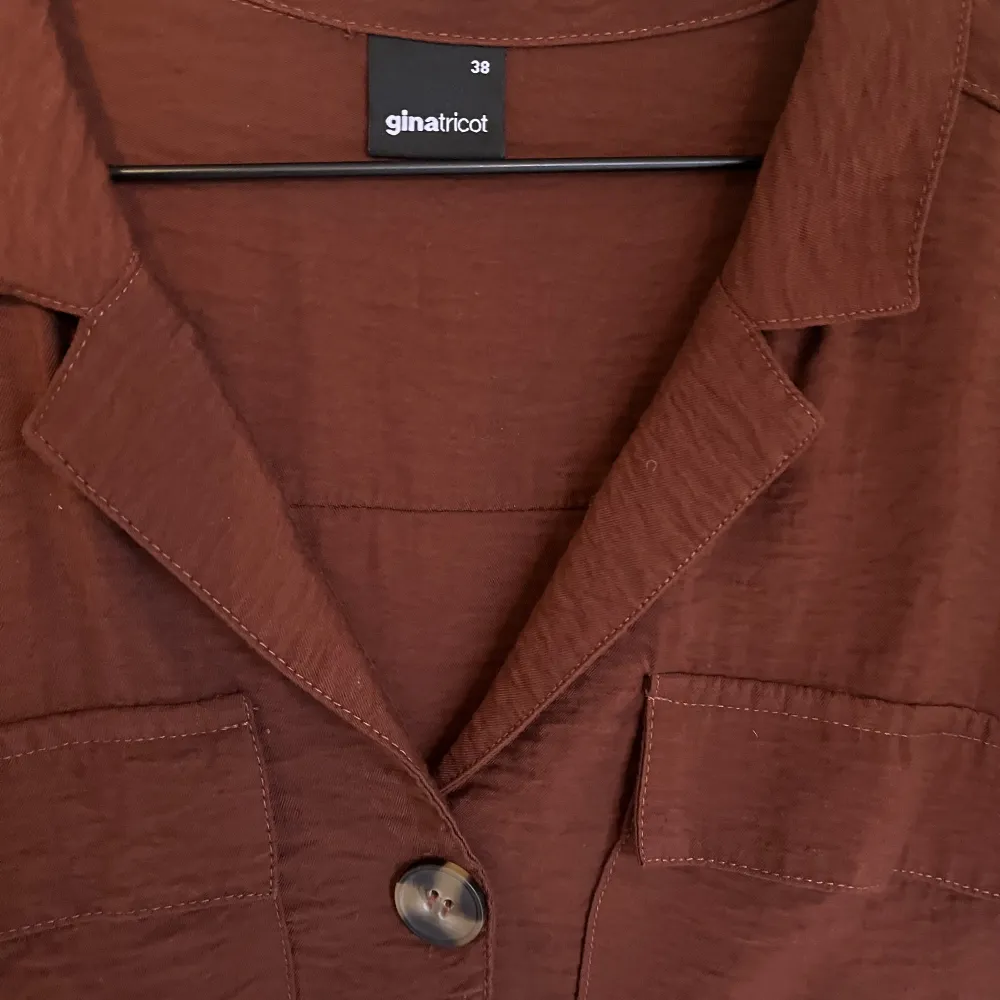 Croppad skjorta med korta ärmar från Monki i en rostbrun färg. Använd 1 gång. Köparen står för frakten🫶🏼. Toppar.