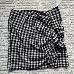 H&M minikjol - Rutig minikjol från H&M med volang på ena sidan. Fint skick, använt endast ett par gånger (se nästa bild för hur den sitter på)