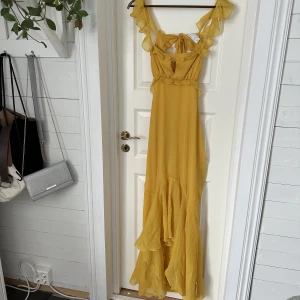 Gul långklänning - Säljer denna supersnygga maxiklänningen med öppen rygg från ASOS. Klänningen är oanvänd och har fortfarande kvar orginalpaketeringen! Orginalpris 749kr, säljes för 500kr inklusive frakt💗