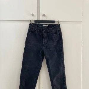 Svarta raka jeans - Raka jeans i ”sliten” svart färg, mot mörkt grå. Rak i stilen, inte riktigt momjeans men inte heller vida. Säljes då de blivit för små för mig.