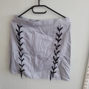 Kort Kjol med snörning  - Helt oanvänd kjol, kort med snörning som går att ta bort 