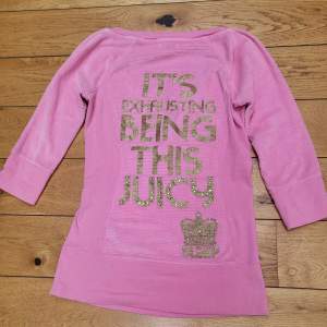 En rosa tröja med text på ryggen. Säljer då den inte kommer till användning😊❤️.