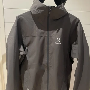 Haglöfs - Haglöfs jacka som är perfekt för våren säljes pga att den är lite lång för mig. Använd fåtal gånger. Eftertraktad färg, svår att få tag på. Strl:M Färg:Grå Nypris: 1495kr 