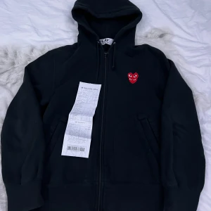 CdG Play Zip Hoodie - Storlek S. Skick 8/10. Säljer för passar ej längre. Kvitto finns. Köpt från Nk. Ny pris 2800 men pris kan diskuteras