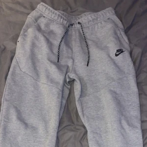 Nike tech grå byxor  - Hej, säljer min gråa Nike tech byxor som jag köpte i höstas. Den är i ny skick är inte använd så mycket kartong kvitto finns! fler bilder får ni om ni skriver till mig!!   Pris kan diskuteras!!