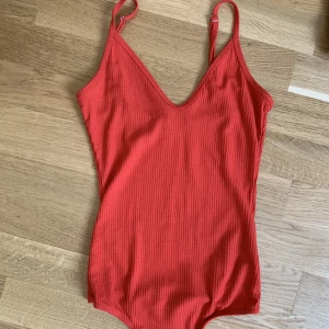 Röd body med låg rygg - Justerbara axelremmar. Låg i rygg, perfekt till sommaren och våren