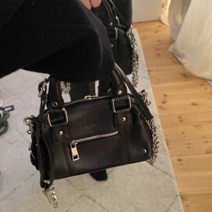 Väska - Säljer den här snygga mini väskan från Nunoo. Går att ta av kedjan om man vill det. Köpt för 1200kr