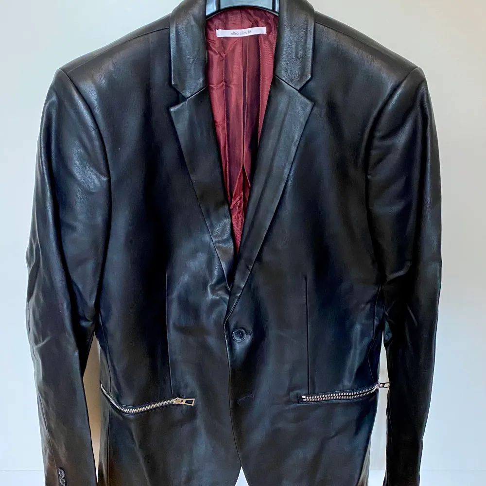 I bought it at Macy’s in Miami Beach for $200. Never worn. Faux leather ultra slim fit with silver zippers. After storage in a case the collar got broken.. Kostymer.