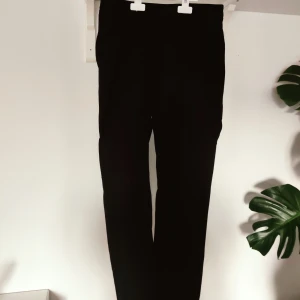 Kostymbyxor - Blåsvarta, klassiska kostymbyxor i M(38)från Lindex. Lite kortare modell i benen.
