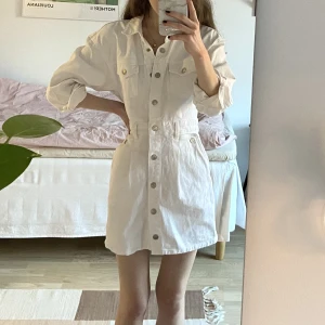 Denimklänning i vitt - Vit knäppbar klänning i jeans/denim från Zara. Använd endast en gång så klänningen är i nyskick.