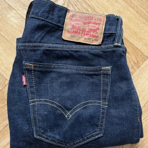 Levis Jeans  - Ett par lågmidjade mörkblå jeans från levis i modellen 527. De är köpta second hand men är i mycket bra skick. Jag är 170cm lång. Storleken är 32 i midjan men sätter sig lågmidjat på mig som har mindre storlek än så vanligtvis och i längden är de 30. 