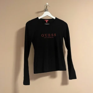 GUESS tröja  - En svart skön tröja, svart med röd tunn text. Nypris 500 kr, använt några gånger så jag säljer den för 170 kr.