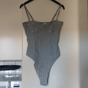 Body - Rutig body med knäppning nertill. Justerbara axelband. Nästan helt oanvänd. För mer info/bilder är det bara att skriva☀️