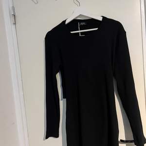 Kort svart långärmad klänning med öppen rygg detalj från Bershka. Klänningen är aldrig använd åker köpt förra året, prislappen sitter fortfarande kvar