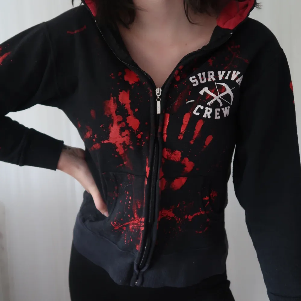 En tjocktröjan med ”blod stänk” och tryck med texten ”zombie killer 13” och ”survivel crew” bra skick men det märks att den är använd. Köpt på blue fox. Hoodies.