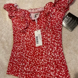 Topp - Topp med blommigt mönster från NELLY. Aldrig använd med prislapp. Storlek xxs.