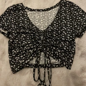 topp från shein - säljer en svartblommig croppad topp med dragsko ifrån shein. strl s. 50kr + frakt💗💗 tryck inte på köp nu!!