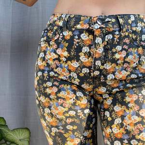 • Blommönstrade skinny jeans • Bra skick, typ vanligt byxor tyg, fickor båda på fram- och baksida. Slim fit hela vägen ner, mid waist fit. Svarta med blommor på.