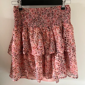 Rosa mönstrad kjol - Säljer denna rosa mönstrad kjol från vero moda köpt för 3 år sen! Använd ett fåtal gånger och är i gott skick! är i strl M men passar bra för både xs-m skulle jag säga!Skriv för mer frågor! Frakt är ej inräknad💗