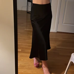 Svart satinkjol från NAKD - Svart a-linje midikjol från NAKD. Som ny.