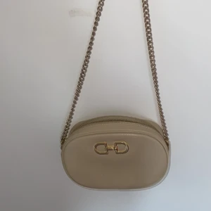 Beige väska  - Helt ny din beige väska med guldiga tjedjor 