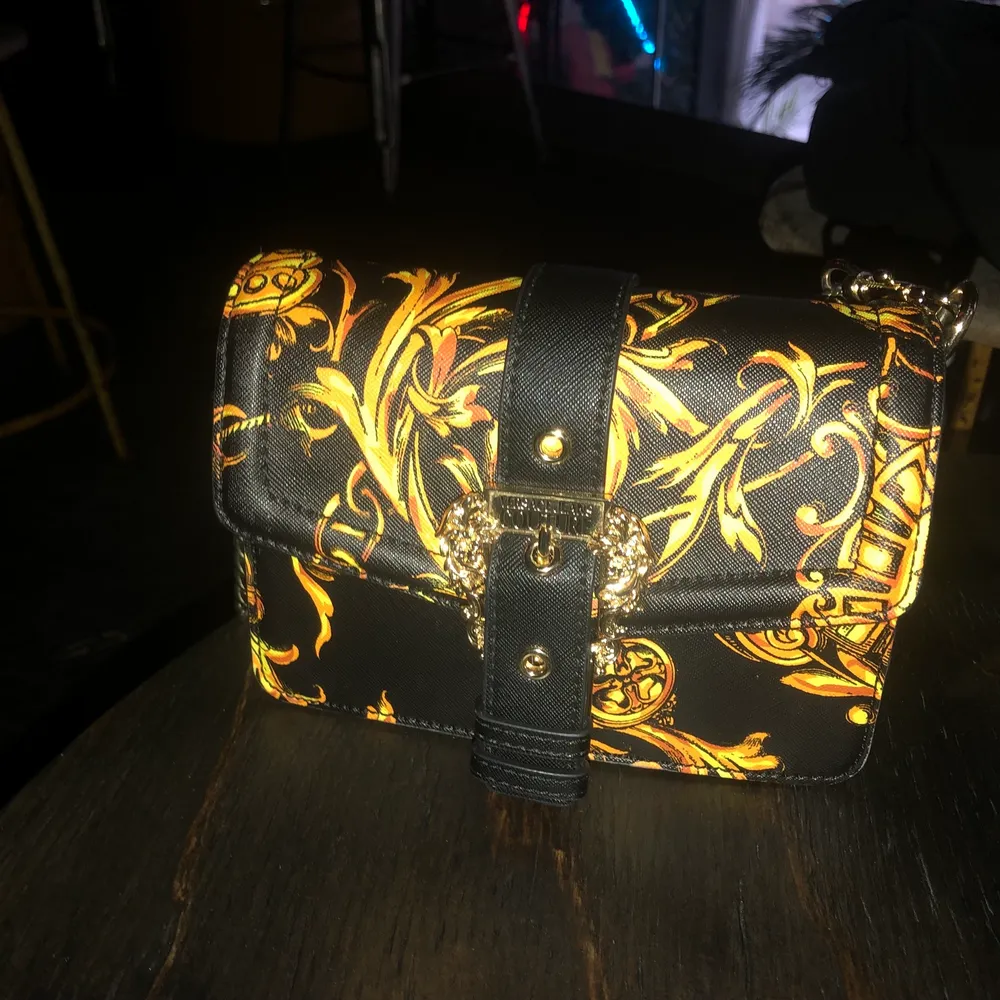 Helt ny Versace jeans couture väska, använd några gånger men är som helt ny! Rymlig men liten i storlek. Dustbag med kommer men har tyvärr inget kvitto då jag fick den i födelsedagspresent . Väskor.