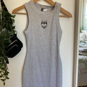 H&m klänning - Grå klänning med ett hjärta på från h&m, använd 1 gång