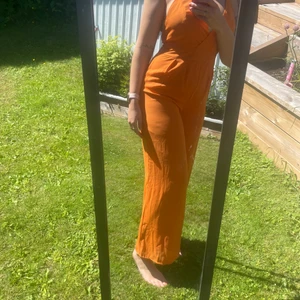 Orange jumpsuit - Veldig fin orange jumpsuit. Kryss på ryggen og litt kortere i ben. Knappen foran har falt av, men sitter fremdeles på den ene siden så må bare sys litt. 